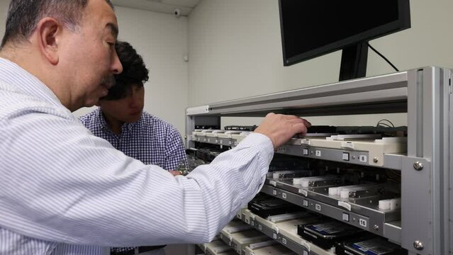 The person in charge explaining in front of the product and the young businessman receiving the explanation 