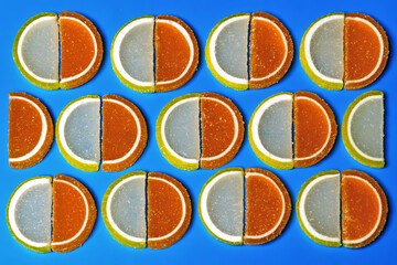 Sweet slices of marmalade lemon and orange on a blue background.