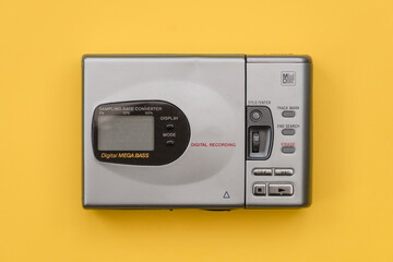 Mini Disc player from the 1990's. Top down view with yellow background.