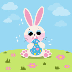 A white rabbit in a flower meadow. Easter bunny with egg.
