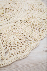 Handmade carpet knitted from natural threads, flooring, natural cotton. Beige handmade carpet. Knitted decorative item