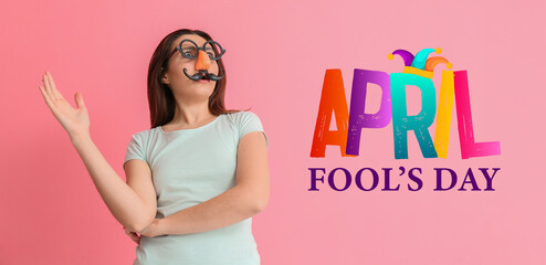 Young woman in funny disguise on pink background. April fools' day celebration