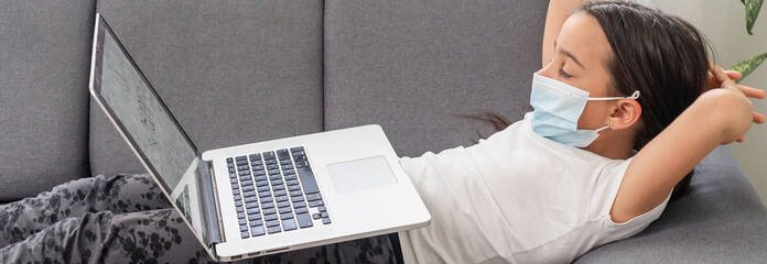 Closeup photo of little pupil school girl talk notebook online lesson video meeting teacher classmates say hi, use facial mask distance quarantine study house room indoors