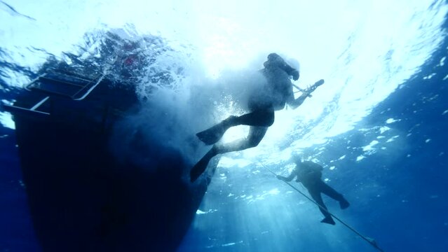 boat underwater scuba diver jumps into water ocean scenery