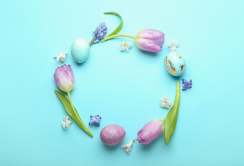 Stylish wreath with painted Easter eggs and beautiful flowers on blue background