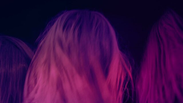 Metal Fans Shaking Their Heads In Colorful Lights
