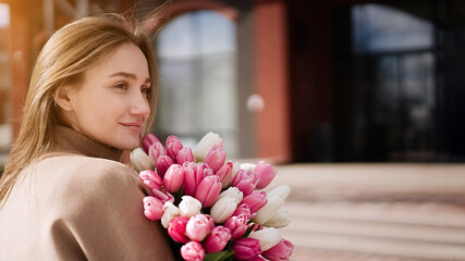 Beautiful girl with tulip flowers in her hands   