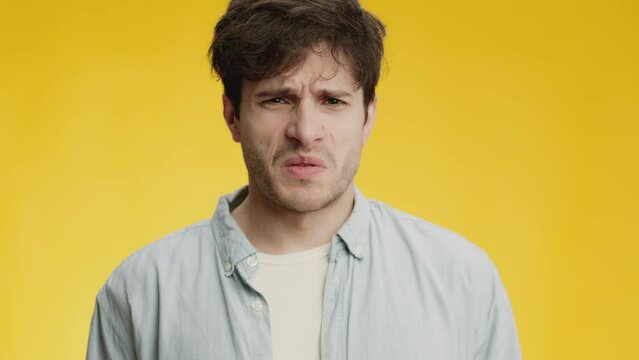 Disgusting air smell. Close up portrait of young man feeling awful aroma, frowning face and feeling gagging sensation