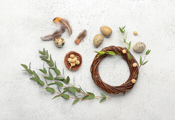 Fototapeta na wymiar Composition with wreath, eucalyptus branches, feathers and Easter eggs on light background