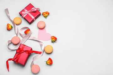 Composition with gifts for International Women's Day celebration, sweet macaroons and rose flowers on white background
