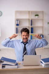Naklejka premium Young male employee working in the office