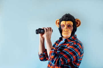 Man with monkey mask using binoculars.