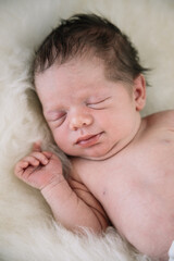 cute small newborn baby sleeping on a sheep fur. High quality photo