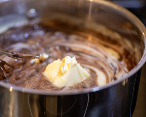 Melting butter and milk chocolate in stove pot melting together to make dessert