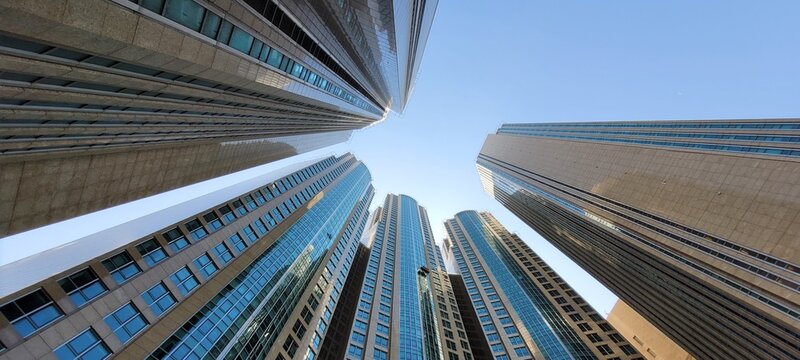 Urbane H&auml;userschlucht blick in den blauen Himmel umgeben von Hochh&auml;usern
