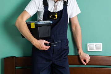 A worker holds a tool case on his shoulder.