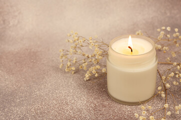 Obraz na płótnie Canvas Soy wax candle in white glass on a beautiful background with copy space
