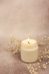 Fototapeta na wymiar Soy wax candle in white glass on a beautiful background with copy space