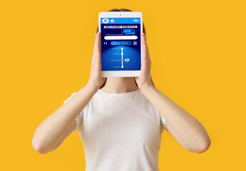 Young woman holding tablet computer with delivery service application on screen against color...