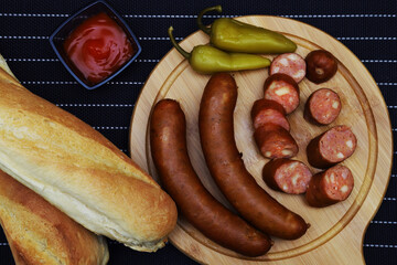 Grilled sausages stuffed with cheese and green peppers, on a serving board
