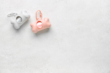 Dispensers with pet waste bags on light background
