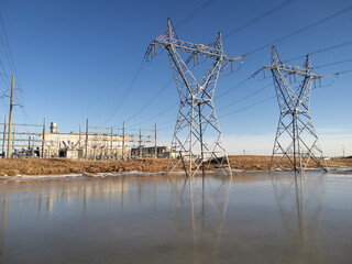 Large transmission towers with power lines and a natural gas plant producing clean energy in Calgary Alberta Canada.