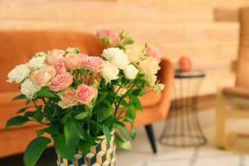 Vase with beautiful roses in living room, closeup