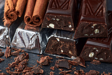 Dark chocolate bars with chopped almonds and cinnamon sticks