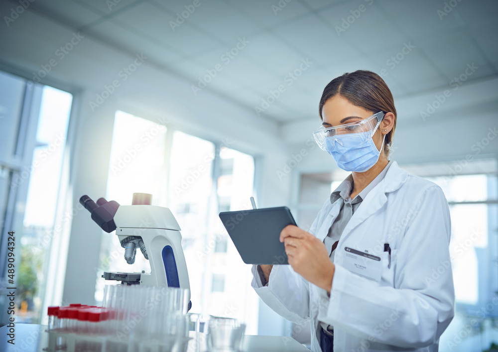 Poster making it easier to publish her findings to the world. shot of a female scientist using a digital ta