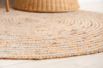 Fototapeta na wymiar Closeup view of stylish wicker rug on light wooden floor