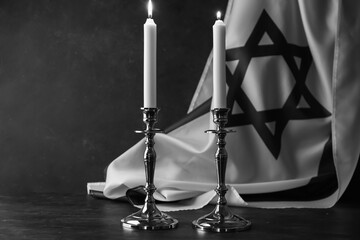 Burning candles and flag of Israel on dark background. Holocaust remembrance day