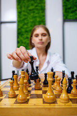Confident business woman playing chess at the table. Intellectual duel in chess. selective focus