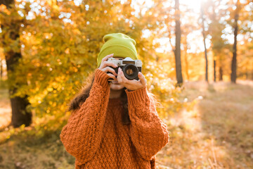 Young woman taking picture in autumn forest - Powered by Adobe