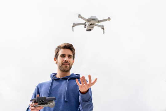 Young man operating a flying drone outdoors