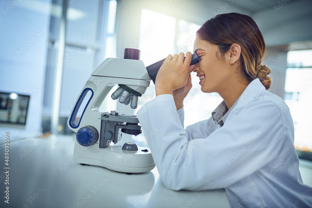 Poster what a fascinating find we have here.... shot of a young scientist using a microscope in a lab.