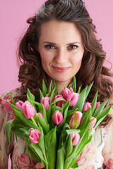Fototapeta premium Portrait of happy woman with long wavy brunette hair on pink