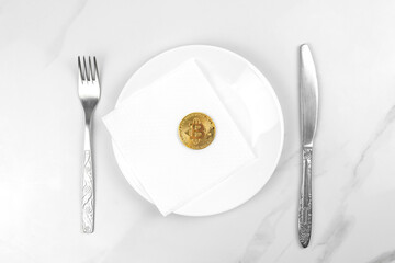 Bitcoin gold coin concept. Cryptocurrency mixed media image. Served bitcoin on a white plate. Marble background