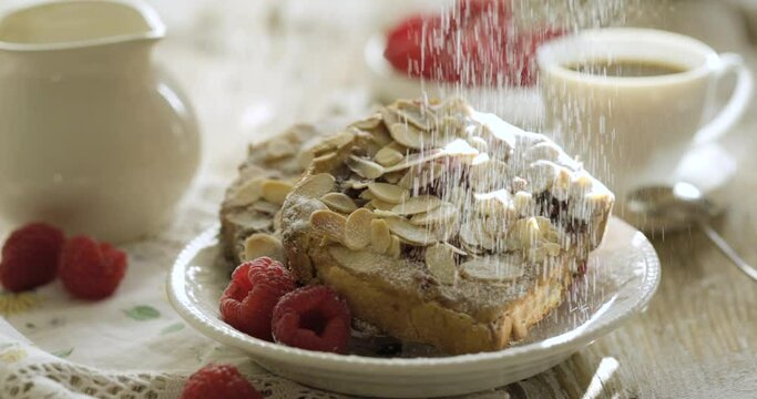 Sweet toast, bostock sprinkled with powdered sugar. Delicious baked dessert or breakfast made of sliced brioche with the addition of orange syrup, almond cream frangipane  and ras