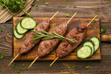 Board of skewers with tasty lula kebab on wooden background © Pixel-Shot