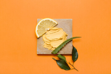 Turmeric mask, lemon and aloe on orange background