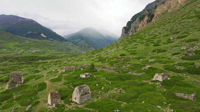 Ruins of medieval buildings in the mountains. In the background are mountains covered in mist. Chegem, Kabardino-Balkaria, Russia.  
