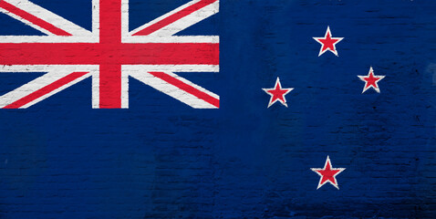 Full frame photo of a weathered flag of New Zealand painted on a plastered brick wall.