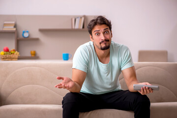 Fototapeta premium Young man watching tv at home