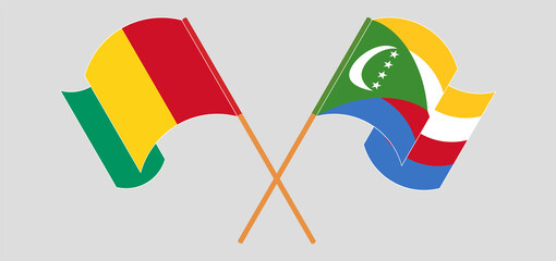 Crossed and waving flags of Guinea and Comoros