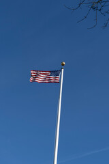 American flag stars and stripes or star spangled banner fluttering in blue sky