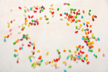 Frame made of different jelly beans on light background