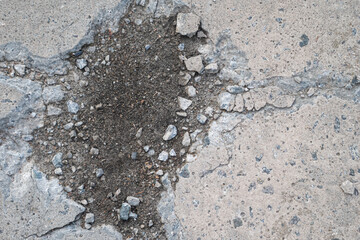 Big hole in light grey asphalt road