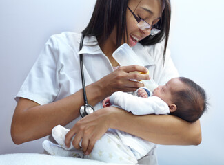 Making a caring contribution to society. Shot of a healthcare worker giving formula to an infant...