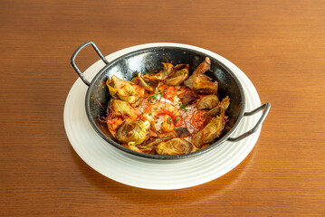 Fantastic recipe for broken fried eggs with fried artichoke hearts and stewed shrimp with chives in a black enamel casserole