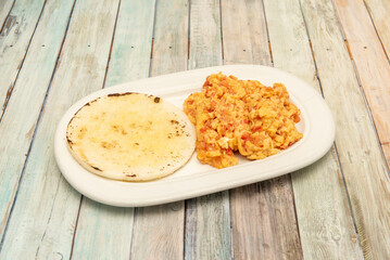 In Colombian and Venezuelan cuisine, Huevos Pericos refers to a dish prepared with scrambled eggs, butter, sautéed chopped onions, bell peppers, and tomatoes.